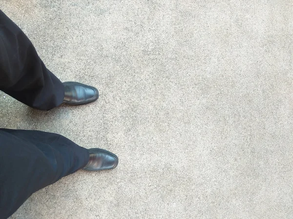 A man with black shoes standing on concrete texture background — Stock Photo, Image