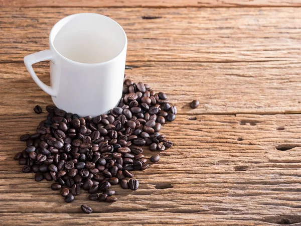 Svart rostade kaffebönor på åldern trä — Stockfoto