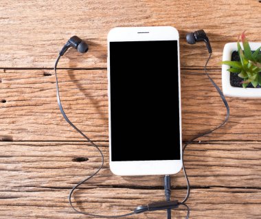akıllı telefon ve kulakları ahşap arka plan üzerinde fiş