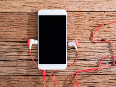 akıllı telefon ve kulakları ahşap arka plan üzerinde fiş