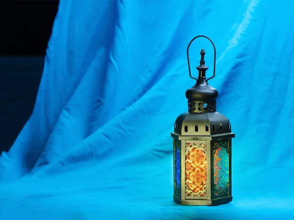 Illuminazione sulla lanterna di stile musulmano che brilla sulla tavola di stoffa — Foto Stock
