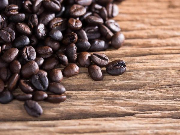 Svart rostade kaffebönor på åldern trä — Stockfoto