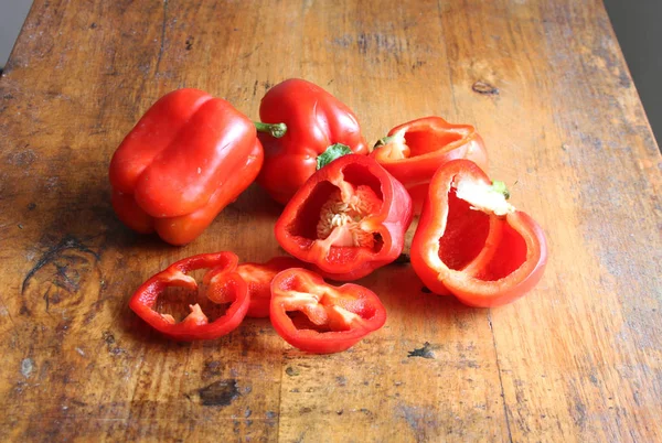 Papriky červené na dřevěném stole — Stock fotografie