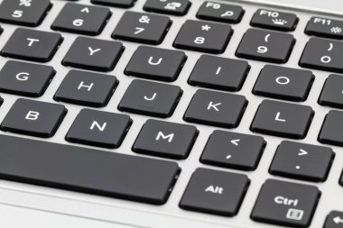 Laptop klavye siyah tuşları ve gri durumda. Portre