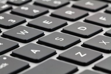 Laptop klavye siyah tuşları ve gri durumda. Portre