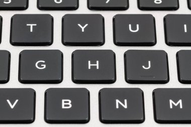 Laptop klavye siyah tuşları ve gri durumda. Portre
