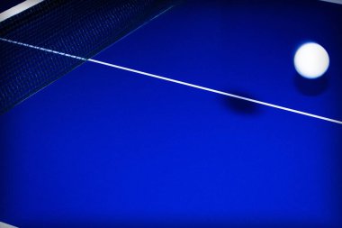 Masa tenisi için beyaz çizgileri olan mavili bir masanın üzerinde top ile arka plan