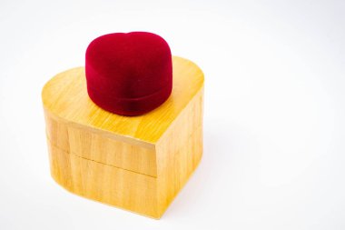 Kırmızı kadife hediye kutusu ve beyaz arka planda izole edilmiş ahşaptan yapılmış kalp. Sevgililer Günü