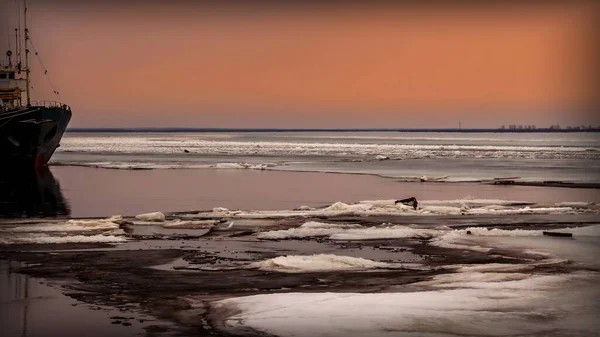 A fishing boat among drifting ice floes on a river at sunset of the day. Severnaya Dvina River, Arkhangelsk Region, Russia — Stock Image Fishing Boat Drifting Ice Floes River Sunset Day Severnaya Dvina Royalty Free Stock Images