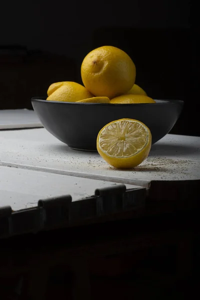 Yellow Lemons Black Bowl White Wooden Table — Stock Photo, Image