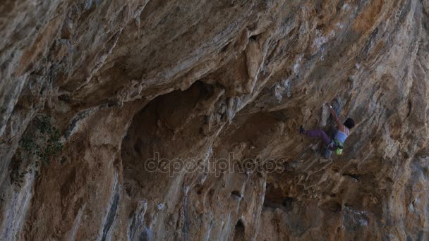 Жіночий альпініст на надзвичайно, що нависають над вапняку — стокове відео