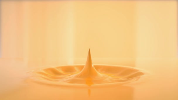 光のオレンジ色の液体の中に落ちて小さなドロップのビュー — ストック動画