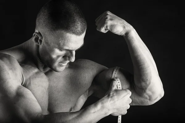 Bodybuilder in demonstrative poses on black — Stock Photo, Image