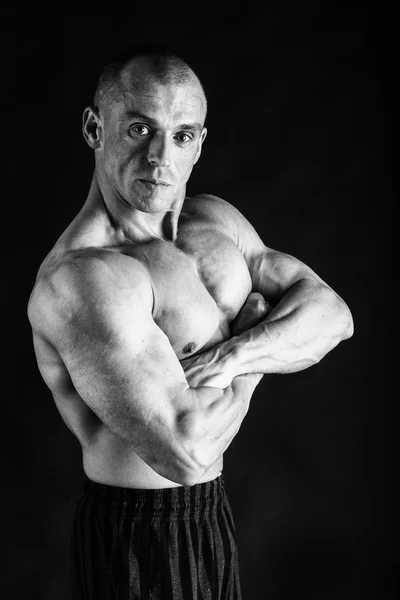 Muž ukazuje svaly v černobílé fotografie. — Stock fotografie
