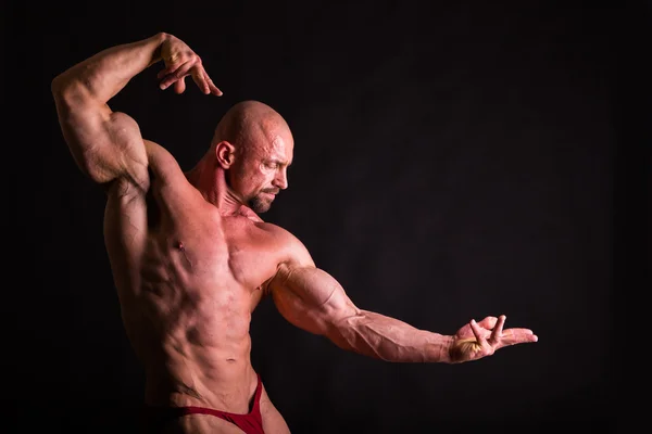 暗い背景上の筋肉を示す男性. — ストック写真