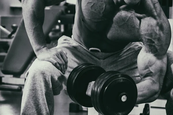 Actividades deportivas en el gimnasio. Hombre fuerte haciendo ejercicios —  Fotos de Stock