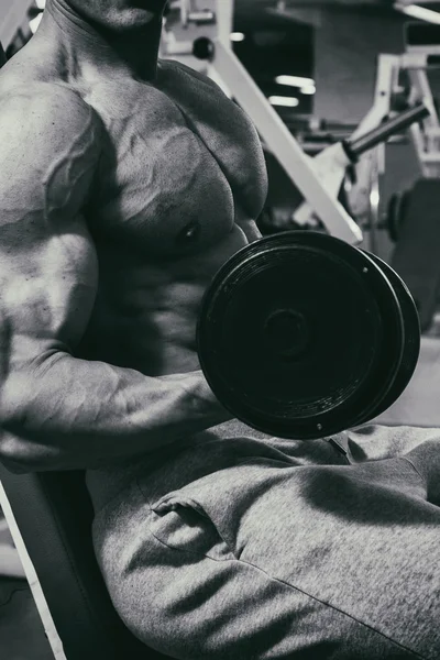 Actividades deportivas en el gimnasio. Hombre fuerte haciendo ejercicios —  Fotos de Stock