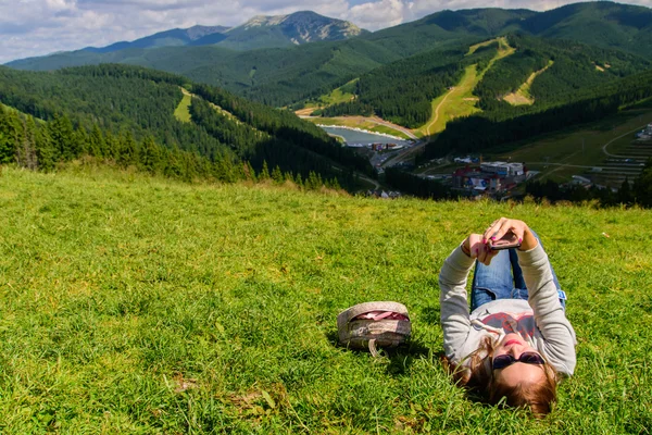 Turismo. A menina senta-se em uma montanha — Fotografia de Stock