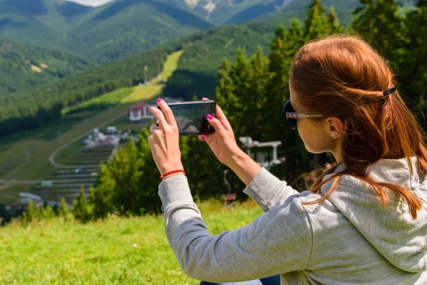 Turismo. A menina senta-se em uma montanha — Fotografia de Stock