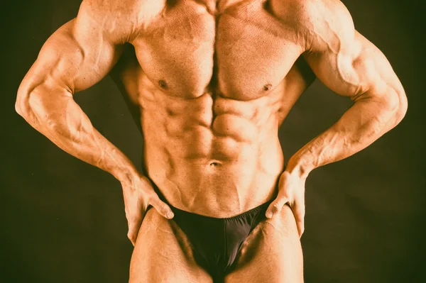 Hombre atlético guapo muy musculoso sobre fondo negro — Foto de Stock