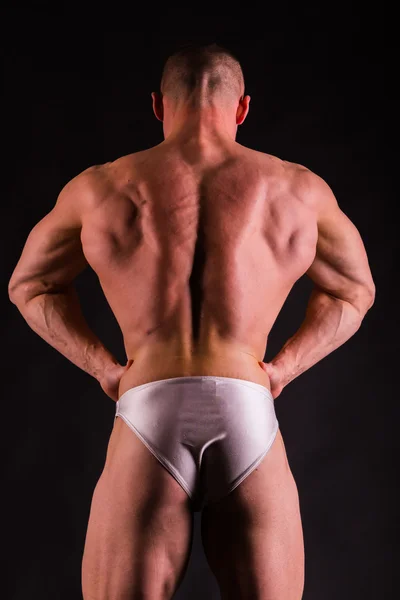 Mycket muskulös snygg atletisk man på svart bakgrund — Stockfoto