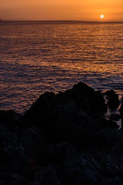 Belo pôr do sol no mar da noite, pedras em primeiro plano — Fotografia de Stock