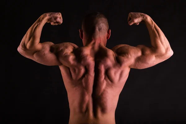 Hombre atlético guapo muy musculoso sobre fondo negro —  Fotos de Stock