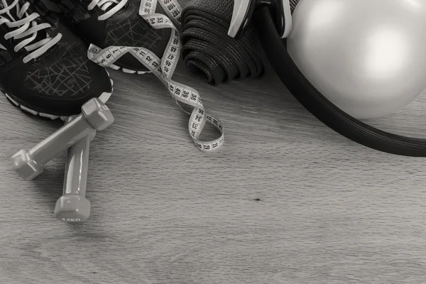 Fitness equipment on a table on a black and white photo. — Stock Photo, Image