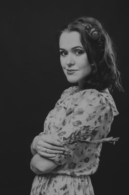 Karanlık bir arka plan üzerinde güzel, gizemli, şirin esmer. Siyah ve beyaz fotoğraf güzel gizemli esmer.