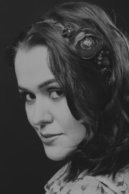 Karanlık bir arka plan üzerinde güzel, gizemli, şirin esmer. Siyah ve beyaz fotoğraf güzel gizemli esmer.