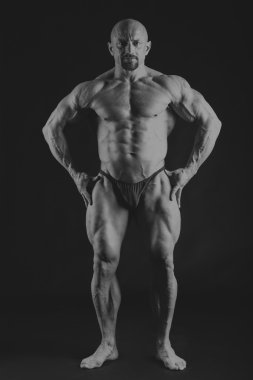 Karanlık bir arka plan üzerinde büyük vücut geliştirmeci