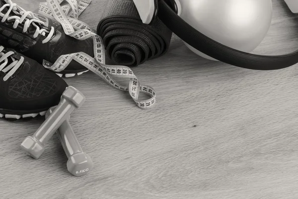 Fitness equipment on a table on a black and white photo. — Stock Photo, Image