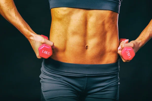 Elegant training, muscular woman on a black background — Stock Photo, Image