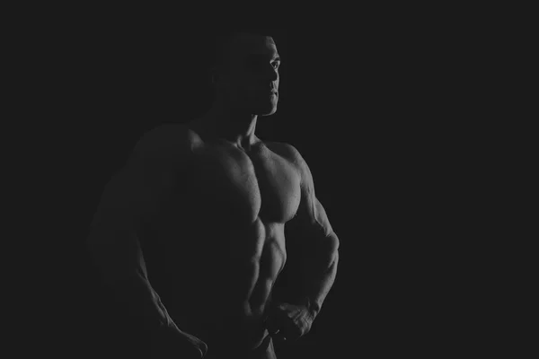 Silhouet van bodybuilder op een donkere achtergrond. — Stockfoto