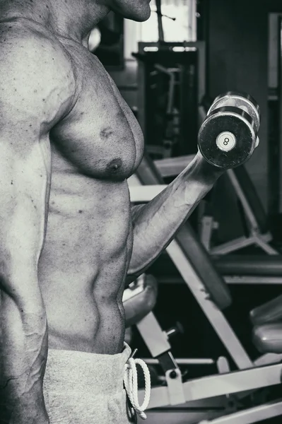 Hombre atlético poder guapo en el entrenamiento bombeo de los músculos con —  Fotos de Stock