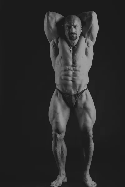 Grote bodybuilder op een donkere achtergrond — Stockfoto
