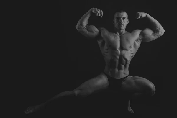 Großer Bodybuilder auf dunklem Hintergrund — Stockfoto