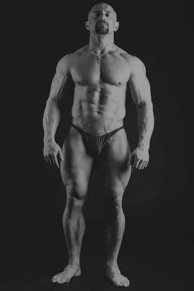 Großer Bodybuilder auf dunklem Hintergrund — Stockfoto