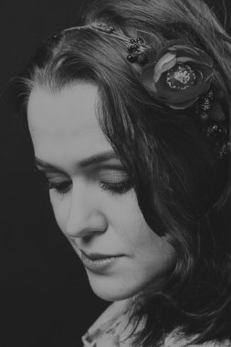 Karanlık bir arka plan üzerinde güzel, gizemli, şirin esmer. Siyah ve beyaz fotoğraf güzel gizemli esmer.