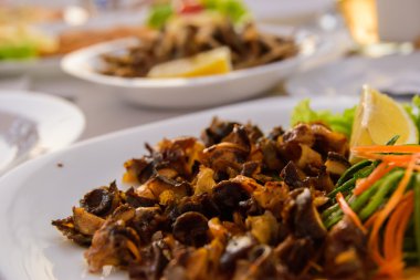 Beyaz bir plaka üzerinde ızgara deniz salyangoz.