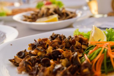 Beyaz bir plaka üzerinde ızgara deniz salyangoz.