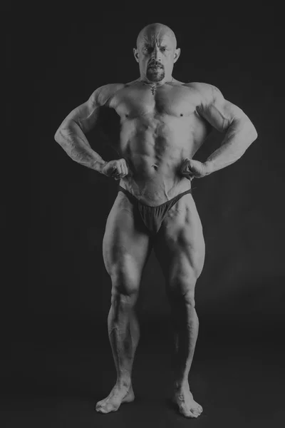 Großer Bodybuilder auf dunklem Hintergrund — Stockfoto