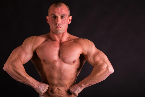 Emotional bodybuilder on black — Stock Photo, Image