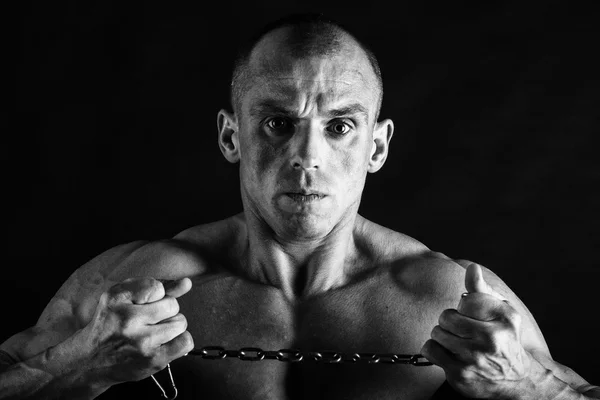 Bodybuilder poseren in verschillende poses aan te tonen hun spieren. Storing op een donkere achtergrond. Mannelijke weergegeven: spieren spannen. Mooi gespierd lichaam atleet. — Stockfoto