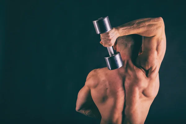 Muscular, relief body bodybuilder on a black background. Black a