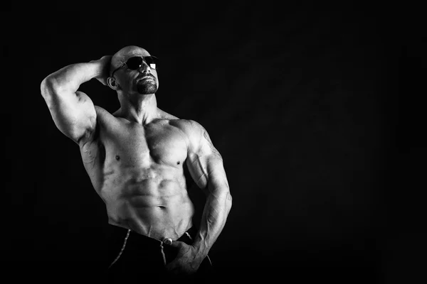 肌肉发达，救济身体健美运动员在黑色背景上。黑色 — 图库照片