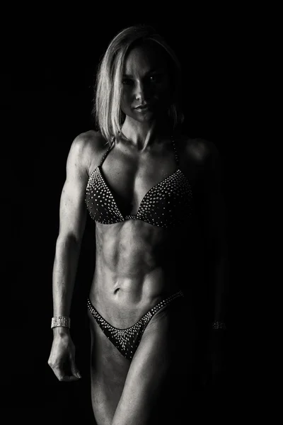 Sexy Fitness-Frau auf dunklem Hintergrund. — Stockfoto