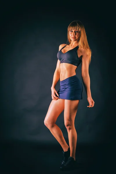 Mujer fitness sexy sobre un fondo oscuro . — Foto de Stock