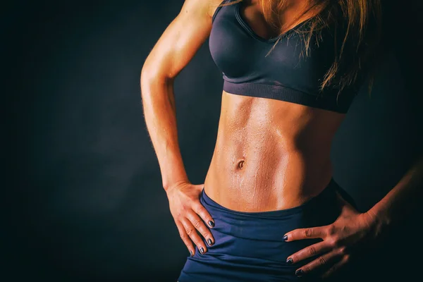 Sexiga fitness kvinna på en mörk bakgrund. — Stockfoto