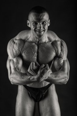 Karanlık bir arka plan üzerinde çok yardım vücut geliştirmeci.